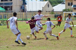 A striker from Baguio City National High School (BCNHS), this season’s stunner in the 2016 MILO Little Olympics North and Central Luzon leg, shields the ball from his competitors. Photo by Milo Little Olympics Team.